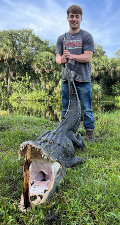 Happy client catches wild alligator on a successful gator hunting trip